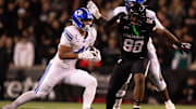 BYU Cougars running back LJ Martin (4) runs for a first down as Cincinnati Bearcats defensive lineman Marquaze Parker (98) defends in the first quarter of the NCAA football game at Nippert Stadium in Cincinnati on Nov. 22, 2025.