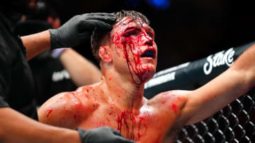 Jul 13, 2024; Denver, Colorado, USA; Drew Dober (red gloves) bleeds from above his eye while fighting Jean Silva (blue gloves) during UFC Fight Night at Ball Arena. Mandatory Credit: Ron Chenoy-USA TODAY Sports