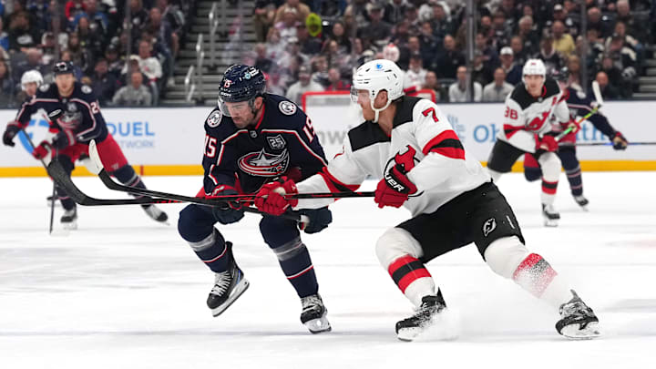 Blue Jackets defenseman Dante Fabbro competes with Devils defenseman Dougie Hamilton. 