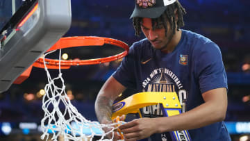 Connecticut Huskies guard Stephon Castle (5) cuts the basketball net after winning the Men's NCAA national championship game against the Purdue Boilermakers at State Farm Stadium in Glendale on April 8, 2024.