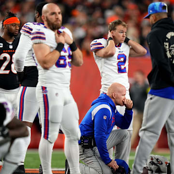 Buffalo Bills head coach Sean McDermott takes a knee as Buffalo Bills safety Damar Hamlin is tended to on the field following a collision in the first quarter of a Week 17 NFL game.