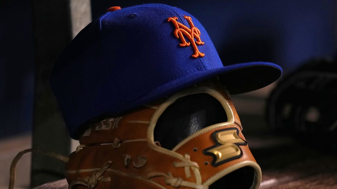 Aug 2, 2021; Miami, Florida, USA;  detailed view of the cap and glove of New York Mets shortstop Javier Baez (not pictured) in the dugout prior to the game against the Miami Marlins at loanDepot park. Mandatory Credit: Jasen Vinlove-Imagn Images