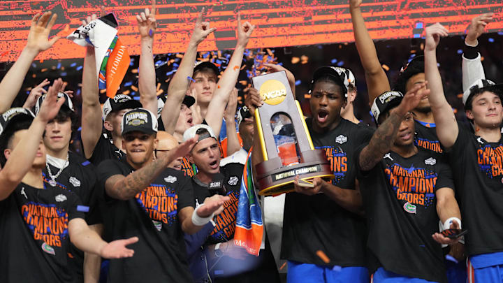 Florida Gators players celebrate with the NCAA Tournament trophy.
