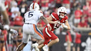 Oct 4, 2025; Louisville, Kentucky, USA; Louisville Cardinals quarterback Miller Moss (7) scrambles under the pressure of Virginia Cavaliers linebacker Kam Robinson (5) during the second half at L&N Federal Credit Union Stadium. Virginia defeated Louisville 30-27. Mandatory Credit: Jamie Rhodes-Imagn Images