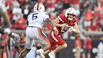 Oct 4, 2025; Louisville, Kentucky, USA; Louisville Cardinals quarterback Miller Moss (7) scrambles under the pressure of Virginia Cavaliers linebacker Kam Robinson (5) during the second half at L&N Federal Credit Union Stadium. Virginia defeated Louisville 30-27. Mandatory Credit: Jamie Rhodes-Imagn Images