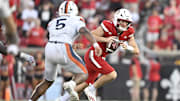 Oct 4, 2025; Louisville, Kentucky, USA; Louisville Cardinals quarterback Miller Moss (7) scrambles under the pressure of Virginia Cavaliers linebacker Kam Robinson (5) during the second half at L&N Federal Credit Union Stadium. Virginia defeated Louisville 30-27. Mandatory Credit: Jamie Rhodes-Imagn Images