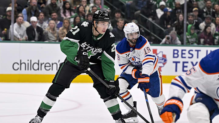 Mar 12, 2026; Dallas, Texas, USA; Dallas Stars left wing Jason Robertson (21) and Edmonton Oilers center Adam Henrique (19) look for the puck during the game between the Stars and the Oilers at the American Airlines Center. Mandatory Credit: Jerome Miron-Imagn Images