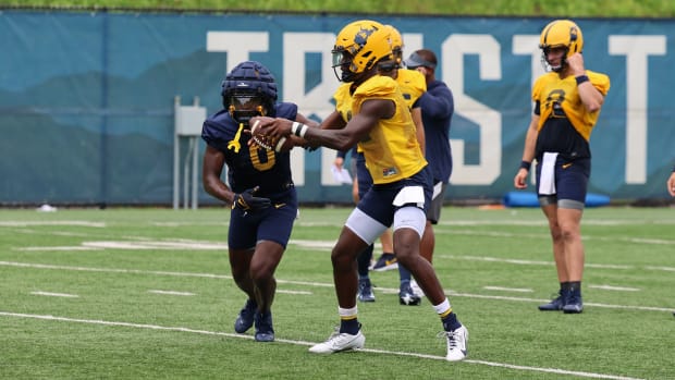 West Virginia quarterback Khalil Wikins hands off to running back Jaylen Anderson during fall camp (2024).