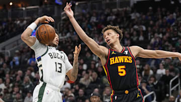 Mar 30, 2025; Milwaukee, Wisconsin, USA;  Atlanta Hawks guard Dyson Daniels (5) and Milwaukee Bucks guard Ryan Rollins (13) reach for the loose ball during the third quarter at Fiserv Forum. Mandatory Credit: Jeff Hanisch-Imagn Images