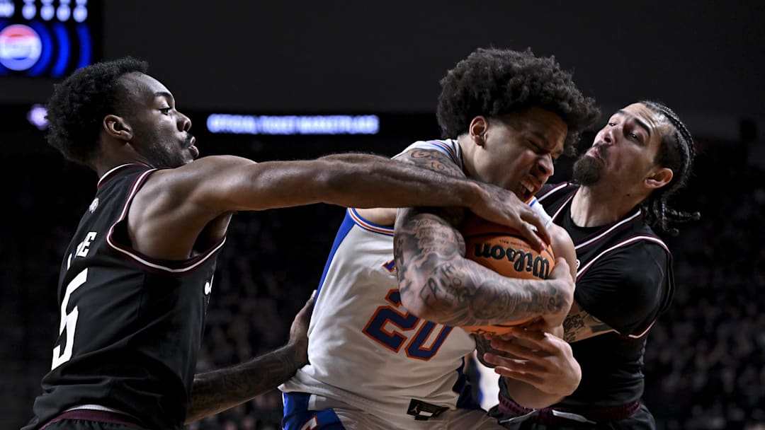 Feb 7, 2026; College Station, Texas, USA; Texas A&M Aggies guard Pop Isaacs (2) and Texas A&M Aggies guard Jacari Lane (5) attempt to grab the ball as Florida Gators guard Isaiah Brown (20) attempts to secure during the first half at Reed Arena. Mandatory Credit: Maria Lysaker-Imagn Images 