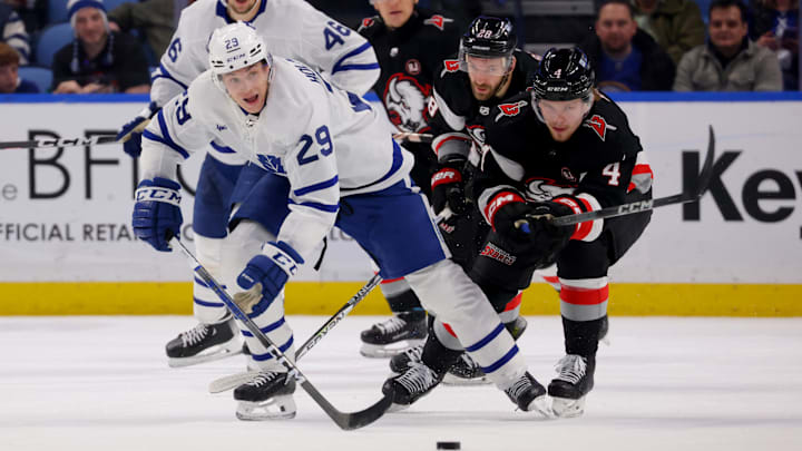 Mar 30, 2024; Buffalo, New York, USA;  Toronto Maple Leafs right wing Pontus Holmberg (29) and Buffalo Sabres defenseman Bowen Byram (4) go after a loose puck during the third period at KeyBank Center. Mandatory Credit: Timothy T. Ludwig-Imagn Images