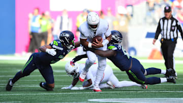 Nov 9, 2025; Seattle, Washington, USA; Arizona Cardinals quarterback Jacoby Brissett (7) is sacked by Seattle Seahawks safety Nick Emmanwori (3) and Seattle Seahawks defensive end DeMarcus Lawrence (0) during the second quarter at Lumen Field. Mandatory Credit: Steven Bisig-Imagn Images