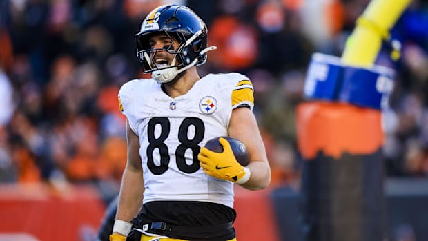Football player in white uniform reacts to touchdow