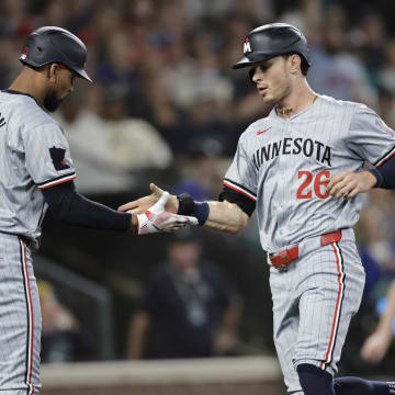 Minnesota Twins right fielder Max Kepler (26) scores and is greeted by Minnesota Twins outfielder Byron Buxton (25) during the second inning at T-Mobile Park in Seattle on June 29, 2024. 