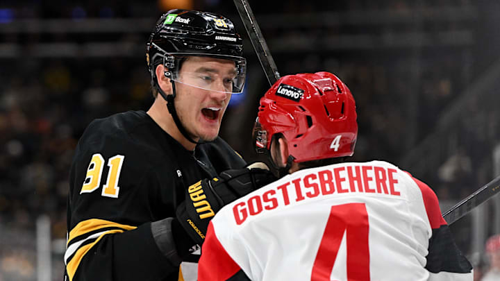 Nov 17, 2025; Boston, Massachusetts, USA; Boston Bruins defenseman Nikita Zadorov (91) shoves Carolina Hurricanes defenseman Shayne Gostisbehere (4) after a whistle during the third period at the TD Garden. Mandatory Credit: Brian Fluharty-Imagn Images