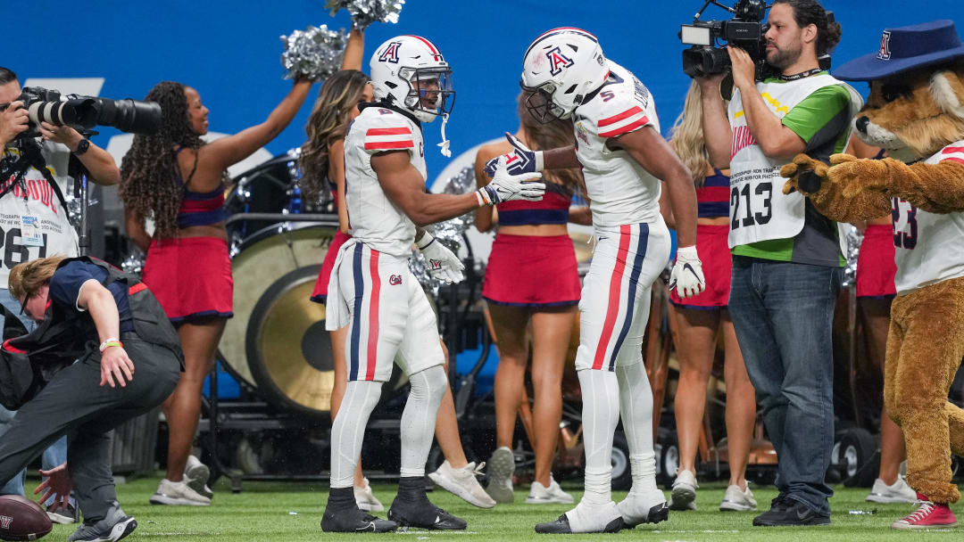 Dec 28, 2023; San Antonio, TX, USA; Arizona Wildcats wide receivers Jacob Cowing (2) and Montana Lemonious-Craig (5) celebrate Cowing's second half touchdown against the Oklahoma Sooners at Alamodome. Mandatory Credit: Daniel Dunn-USA TODAY Sports