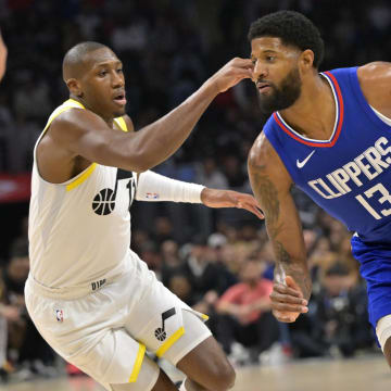 Apr 5, 2024; Los Angeles, California, USA; Los Angeles Clippers forward Paul George (13) is defended by Utah Jazz guard Kris Dunn (11) in the second half at Crypto.com Arena. Mandatory Credit: Jayne Kamin-Oncea-USA TODAY Sports