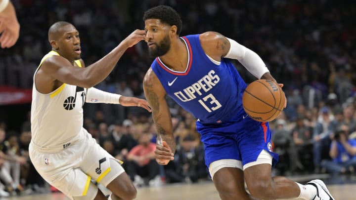 Apr 5, 2024; Los Angeles, California, USA; Los Angeles Clippers forward Paul George (13) is defended by Utah Jazz guard Kris Dunn (11) in the second half at Crypto.com Arena. Mandatory Credit: Jayne Kamin-Oncea-USA TODAY Sports