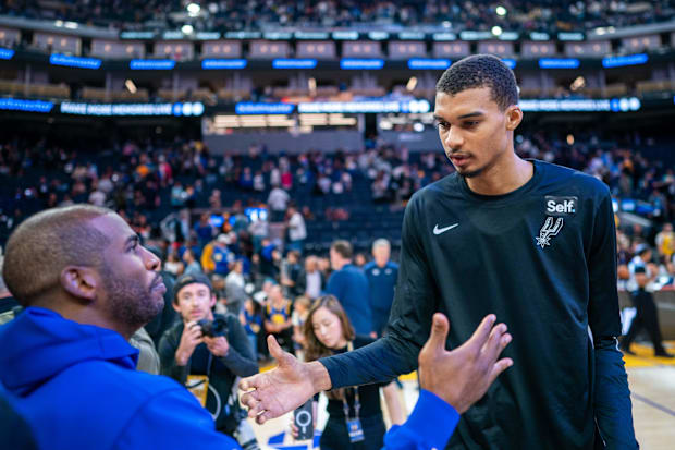 Golden State Warriors guard Chris Paul (3) shakes hands with San Antonio Spurs center Victor Wembanyama (1) after a game.