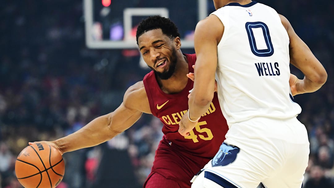 Feb 23, 2025; Cleveland, Ohio, USA; Cleveland Cavaliers guard Donovan Mitchell (45) drives to the basket against Memphis Grizzlies forward Jaylen Wells (0) during the first half at Rocket Arena. Mandatory Credit: Ken Blaze-Imagn Images