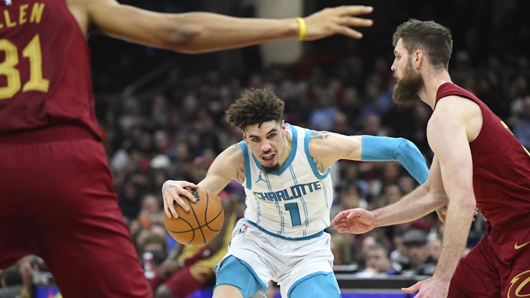 Jan 5, 2025; Cleveland, Ohio, USA; Charlotte Hornets guard LaMelo Ball (1) dribbles beside Cleveland Cavaliers forward Dean Wade (32) in the second quarter at Rocket Mortgage FieldHouse. Mandatory Credit: David Richard-Imagn Images