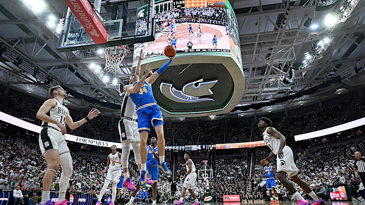Feb 17, 2026; East Lansing, Michigan, USA; UCLA Bruins forward Tyler Bilodeau (34) tries a reverse shot off the glass during the first half against the Michigan State Spartans at Jack Breslin Student Events Center. Mandatory Credit: Dale Young-Imagn Images