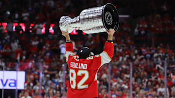 Jun 24, 2024; Sunrise, Florida, USA; Florida Panthers center Kevin Stenlund (82) lifts the cup after winning game seven of the 2024 Stanley Cup Final against the Edmonton Oilers at Amerant Bank Arena. Mandatory Credit: Sam Navarro-Imagn Images