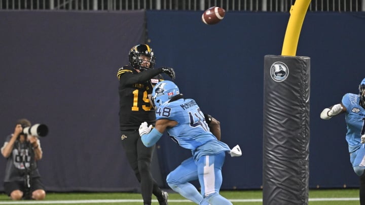 Jun 18, 2023; Toronto, Ontario, CAN;  Hamilton Tiger-Cats quarterback Bo Levi Mitchell (19) throws the ball under pressure from Toronto Argonauts linebacker Wynton McManis (48) in the fourth quarter at BMO Field. Mandatory Credit: Dan Hamilton-USA TODAY Sports