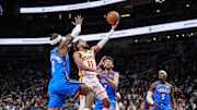 Oct 25, 2025; Atlanta, Georgia, USA; Atlanta Hawks guard Trae Young (11) goes to the basket between Oklahoma City Thunder guard Shai Gilgeous-Alexander (2) and center Chet Holmgren (7) during the first half at State Farm Arena. Mandatory Credit: Dale Zanine-Imagn Images
