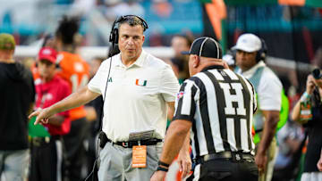 Nov 8, 2025; Miami Gardens, Florida, USA; Miami Hurricanes head coach Mario Cristobal talks to an official during a timeout in a game against the Syracuse Orange during the second quarter at Hard Rock Stadium. Mandatory Credit: Jeff Romance-Imagn Images