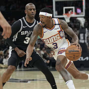 Feb 20, 2025; Austin, Texas, USA; Phoenix Suns guard Bradley Beal (3) drives to the basket against San Antonio Spurs guard Chris Paul (3) during the first half the San Antonio Spurs at Moody Center. Mandatory Credit: Scott Wachter-Imagn Images