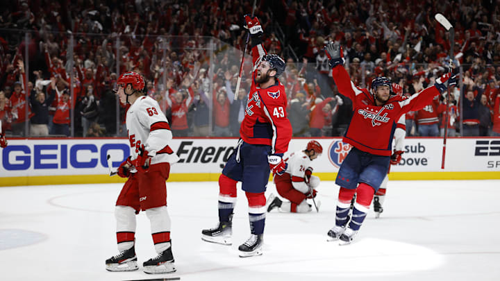 May 8, 2025; Washington, District of Columbia, USA; Washington Capitals right wing Tom Wilson (43) celebrates with Capitals center Nic Dowd (26) after scoring an empty net goal as Carolina Hurricanes right wing Jackson Blake (53) looks on in the third period in game two of the second round of the 2025 Stanley Cup Playoffs at Capital One Arena. Mandatory Credit: Geoff Burke-Imagn Images