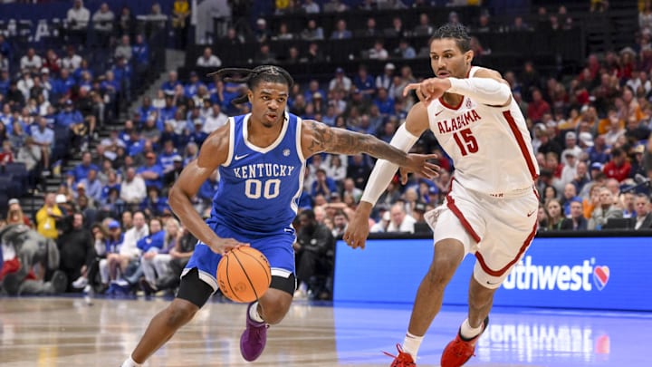 Mar 14, 2025; Nashville, TN, USA;  Kentucky Wildcats guard Otega Oweh (00) dribbles past Alabama Crimson Tide forward Jarin Stevenson (15) during the second half at Bridgestone Arena. Mandatory Credit: Steve Roberts-Imagn Images