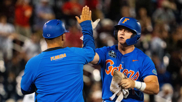 Jun 15, 2024; Omaha, NE, USA; Florida Gators third baseman Dale Thomas (1) celebrates with assistant coach Taylor Black after hitting an RBI double against the Texas A&M Aggies during the seventh inning at Charles Schwab Field Omaha. Mandatory Credit: Dylan Widger-USA TODAY Sports