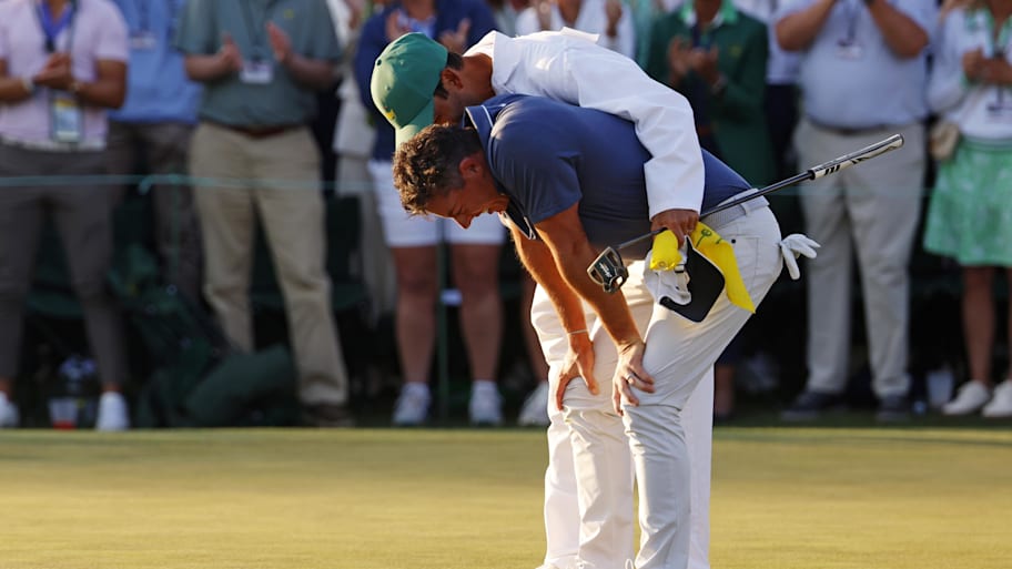 Rory McIlroy celebrates with his caddy, Harry Diamond, after winning in a playoff during the final round of the Masters.
