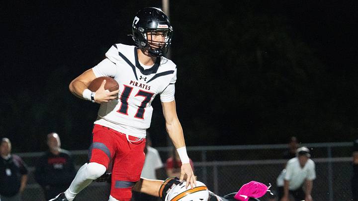 Logan Flaherty, the quarterback of Port Charlotte eludes a Dunbar defender during a game at Dunbar on Friday, Oct. 10, 2025. Port Charlotte won.