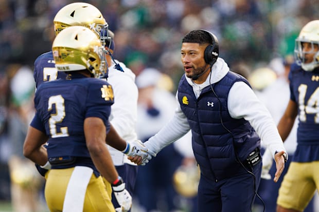 Marcus Freeman shakes a player’s hand on the sideline.
