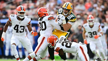 Aug 10, 2024; Cleveland, Ohio, USA; Cleveland Browns linebacker Devin Bush (30) and cornerback Myles Harden (26) tackle Green Bay Packers tight end Joel Wilson (82) during the first quarter at Cleveland Browns Stadium. Mandatory Credit: Ken Blaze-Imagn Images