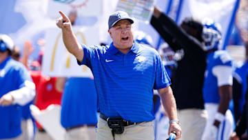 Aug 30, 2025; Lexington, Kentucky, USA; Kentucky Wildcats head coach Mark Stoops discusses a play with a referee during the first quarter against the Toledo Rockets at Kroger Field. Mandatory Credit: Jordan Prather-Imagn Images