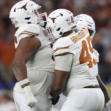 Jan 10, 2025; Arlington, Texas, USA; Texas Longhorns defensive lineman Alfred Collins (95) and defensive lineman Vernon Broughton (45) celebrate after a sack during the third quarter of the College Football Playoff semifinal against the Ohio State Buckeyes in the Cotton Bowl at AT&T Stadium. Mandatory Credit: Tim Heitman-Imagn Images