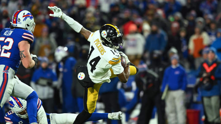 Jan 15, 2024; Orchard Park, New York, USA; Pittsburgh Steelers wide receiver George Pickens (14) outs runs a tackle attempt by Buffalo Bills safety Micah Hyde (23) in the second half in a 2024 AFC wild card game at Highmark Stadium. Mandatory Credit: Mark Konezny-USA TODAY Sports