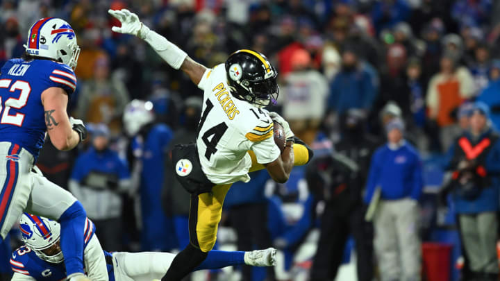 Jan 15, 2024; Orchard Park, New York, USA; Pittsburgh Steelers wide receiver George Pickens (14) outs runs a tackle attempt by Buffalo Bills safety Micah Hyde (23) in the second half in a 2024 AFC wild card game at Highmark Stadium. Mandatory Credit: Mark Konezny-USA TODAY Sports