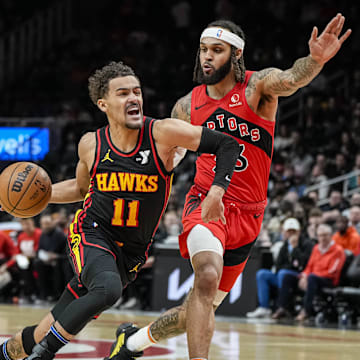 Feb 23, 2024; Atlanta, Georgia, USA; Atlanta Hawks guard Trae Young (11) dribbles guarded by Toronto Raptors guard Gary Trent Jr. (33) during the first half at State Farm Arena. Mandatory Credit: Dale Zanine-Imagn Images