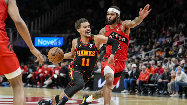 Feb 23, 2024; Atlanta, Georgia, USA; Atlanta Hawks guard Trae Young (11) dribbles guarded by Toronto Raptors guard Gary Trent Jr. (33) during the first half at State Farm Arena. Mandatory Credit: Dale Zanine-Imagn Images