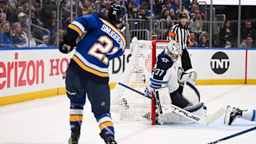 May 2, 2025; St. Louis, Missouri, USA; St. Louis Blues right wing Jimmy Snuggerud (21) is unable to score past Winnipeg Jets goaltender Connor Hellebuyck (37) during the second period in game six of the first round of the 2025 Stanley Cup Playoffs at Enterprise Center. Mandatory Credit: Connor Hamilton-Imagn Images