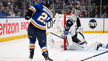 May 2, 2025; St. Louis, Missouri, USA; St. Louis Blues right wing Jimmy Snuggerud (21) is unable to score past Winnipeg Jets goaltender Connor Hellebuyck (37) during the second period in game six of the first round of the 2025 Stanley Cup Playoffs at Enterprise Center. Mandatory Credit: Connor Hamilton-Imagn Images