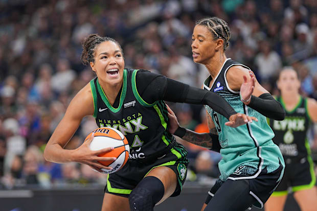 Minnesota Lynx forward Napheesa Collier dribbles against New York Liberty guard Natasha Cloud.