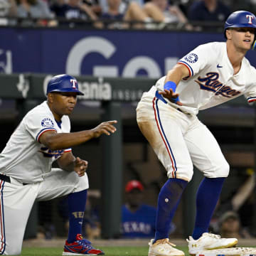 Mar 31, 2024; Arlington, Texas, USA; Texas Rangers third baseman Josh Jung (6) and third base coach Tony Beasley (27) celebrate after Jung hits a triple against the Chicago Cubs during the game at Globe Life Field. Mandatory Credit: Jerome Miron-USA TODAY Sports