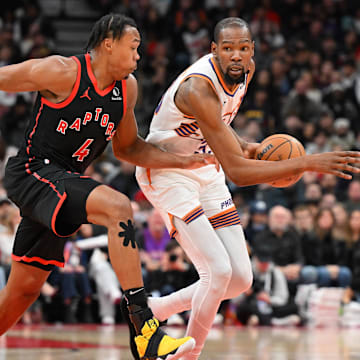 Feb 23, 2025; Toronto, Ontario, CAN;  Phoenix Suns forward Kevin Durant (35) dribbles the ball as Toronto Raptors forward Scottie Barnes (4) defends in the second half at Scotiabank Arena. Mandatory Credit: Dan Hamilton-Imagn Images