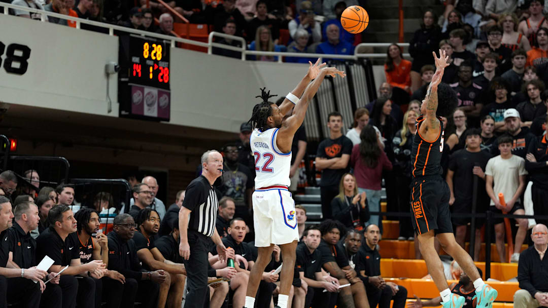 Kansas Jayhawks guard Darryn Peterson (22) shoots a 3-pointer over Oklahoma State Cowboys guard Vyctorius Miller (5) during a men's college basketball game between the Oklahoma State Cowboys and the Kansas Jayhawks at Gallagher-Iba Arena in Stillwater, Okla., Wednesday, Feb. 18, 2026.
